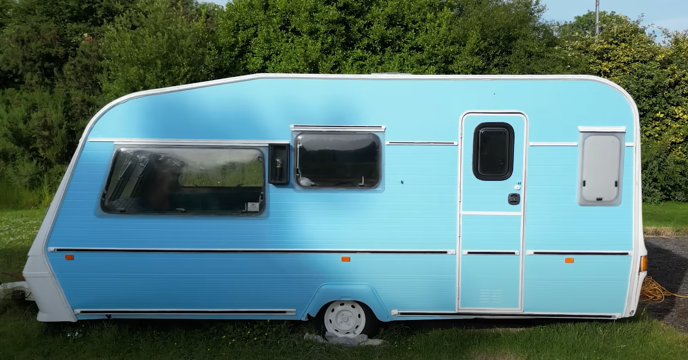 Kevin painted the caravan blue on the side and put rocks around the wheels to stop it moving