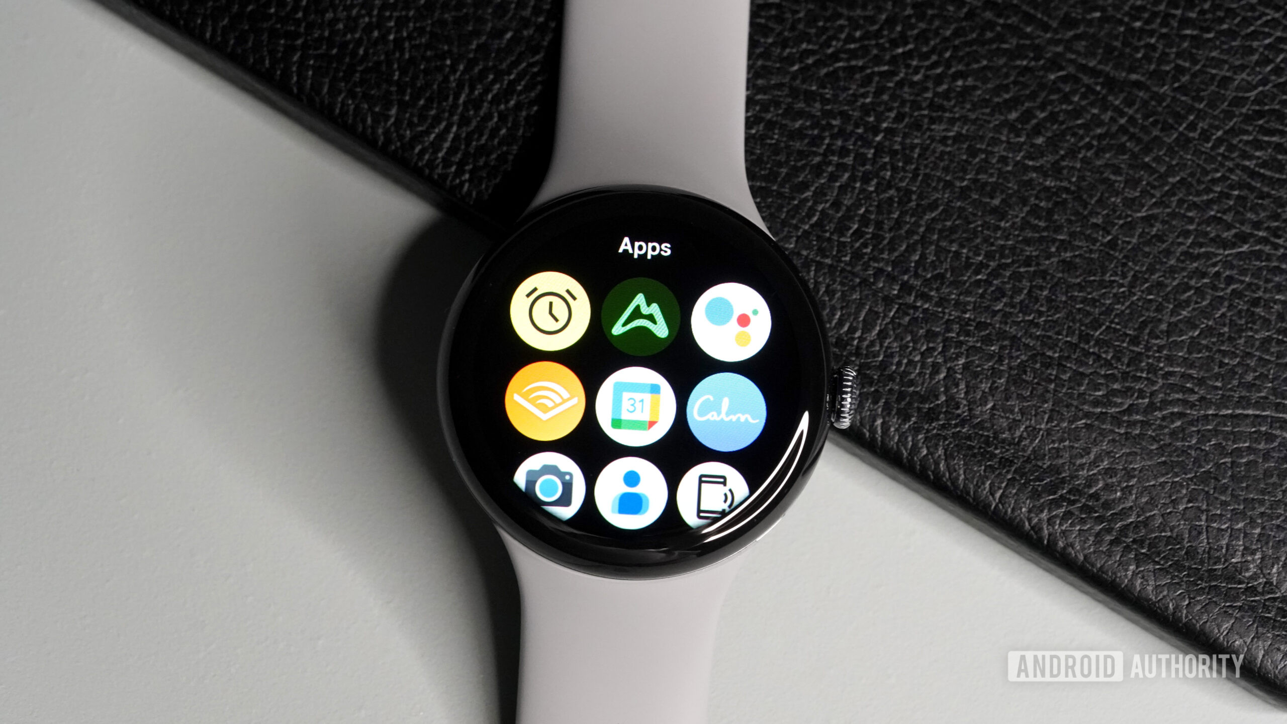 A Google Pixel Watch 3 dispalys a grid-style apps library.