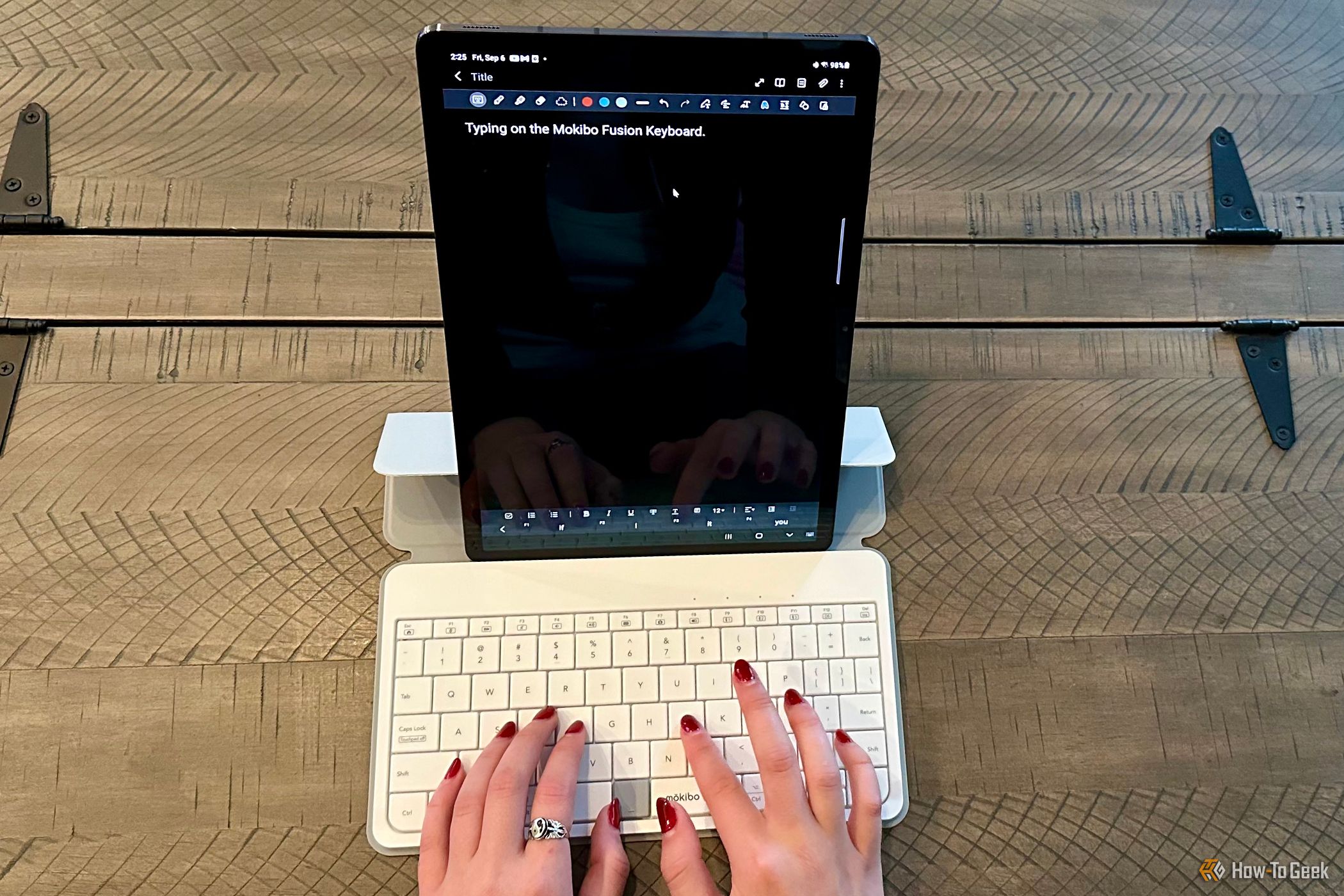 Woman's hands typing on a Mokibo Fusion Keyboard in front of a Samsung Galaxy Tab S7+