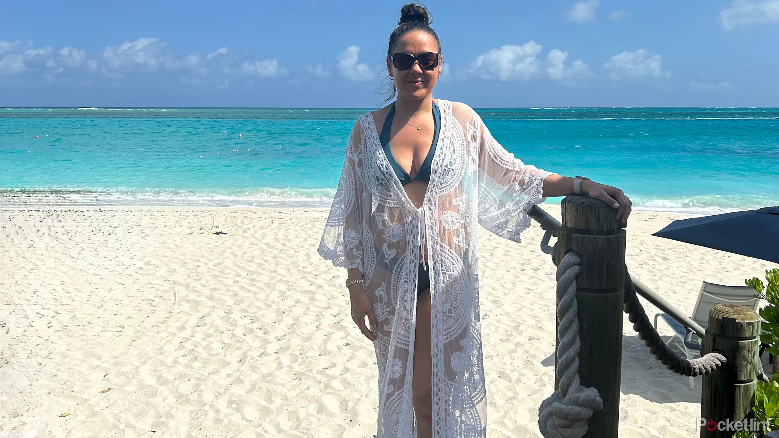 A woman standing in front of a beautiful beach.