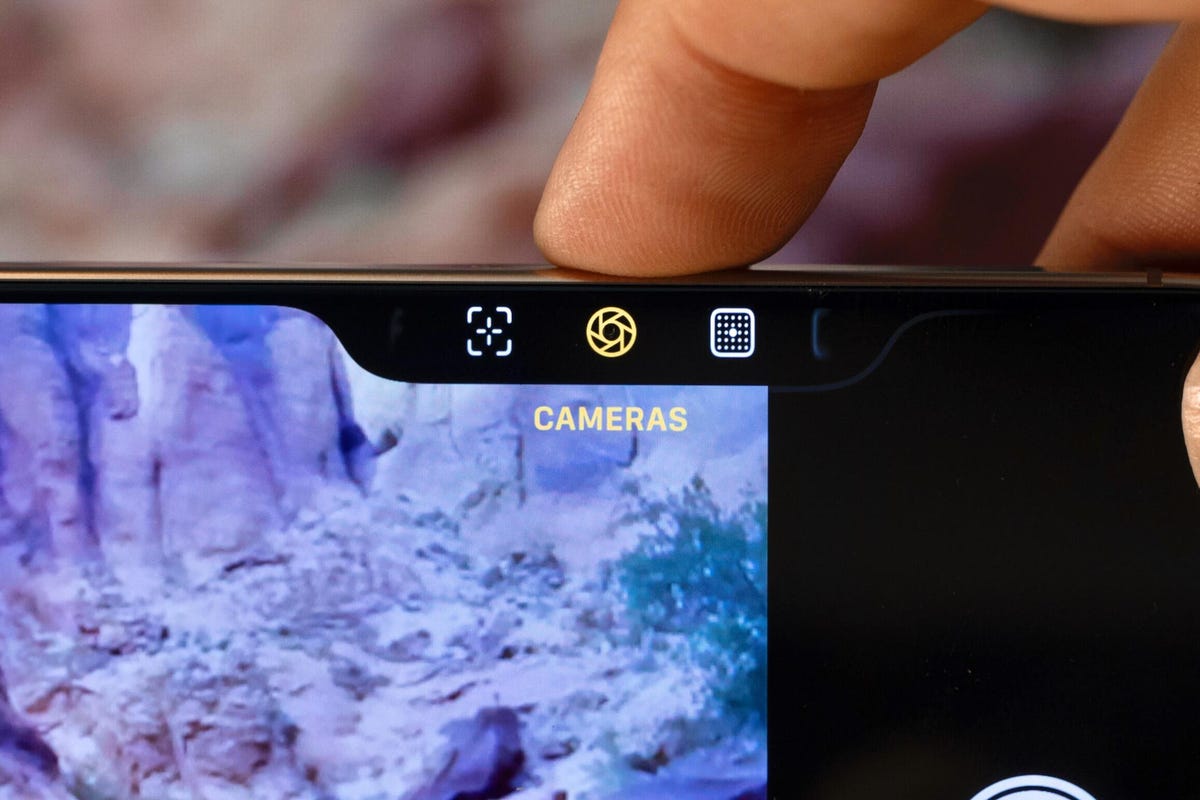 A finger pressing the iPhone 16's camera control button