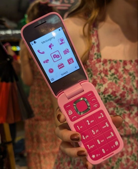 Courtney holding the Barbie flip phone