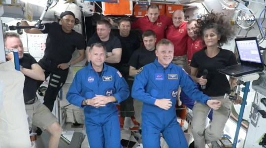 In this image made from a NASA livestream, the two astronauts stuck at the International Space Station since June 2024, Butch Wilmore, far left, and Suni Williams, far right, welcome two new residents who flew up on SpaceX, NASA's Nick Hague, front left in blue, and the Russian Space Agency's Alexander Gorbunov, front right in blue, Sunday, Sept. 29, 2024. Behind them, from left in black, are NASA's Jeanette Epps, Russia's Alexander Grebenkin, NASA's Mike Barratt and NASA's Matthew Dominick. From left, wearing red, are Russia's Ivan Vagner, NASA's Don Pettit and Russia's Alexei Ovchinin. (NASA via AP)