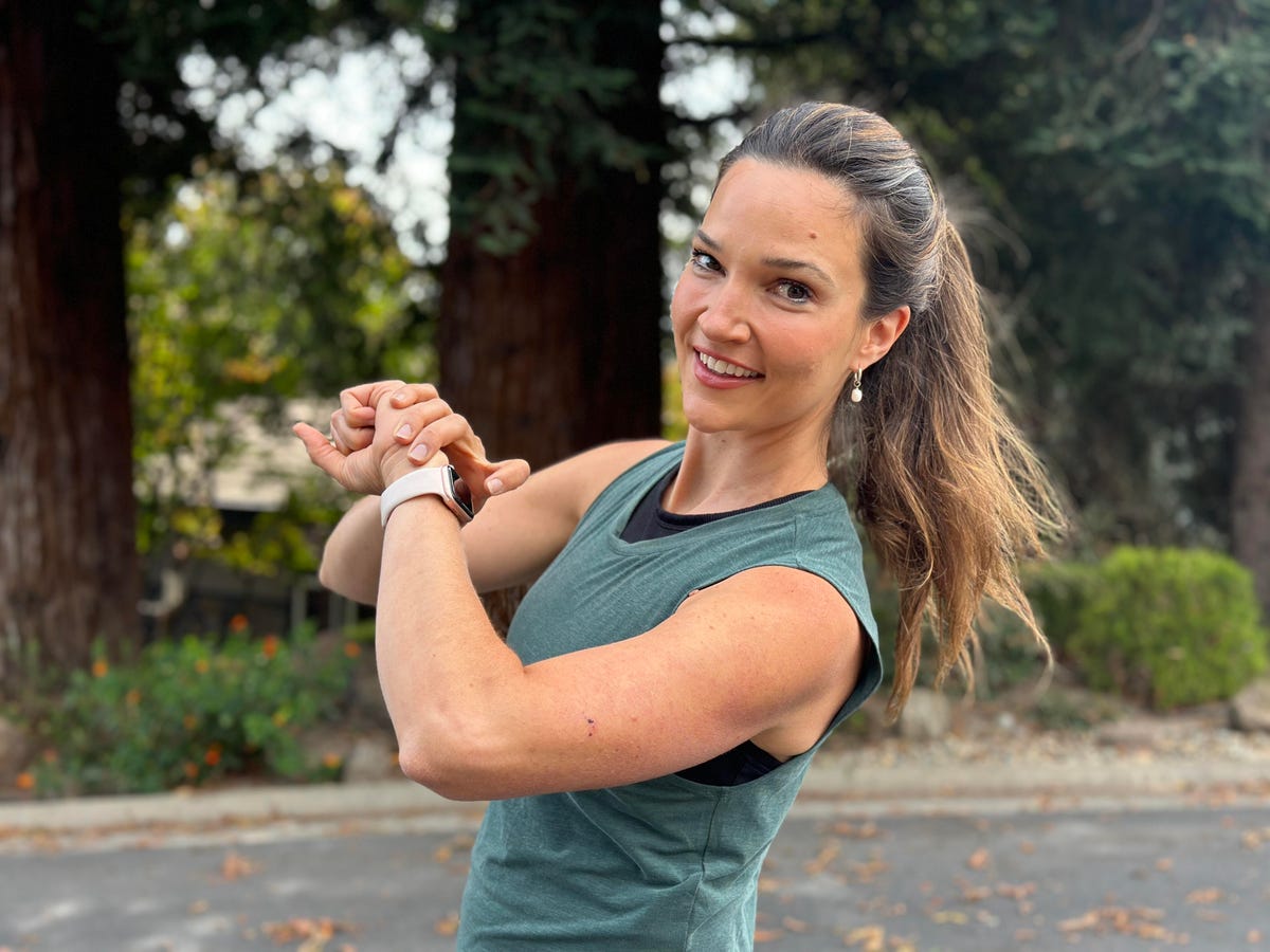 woman running down street and checking smartwatch on wrist