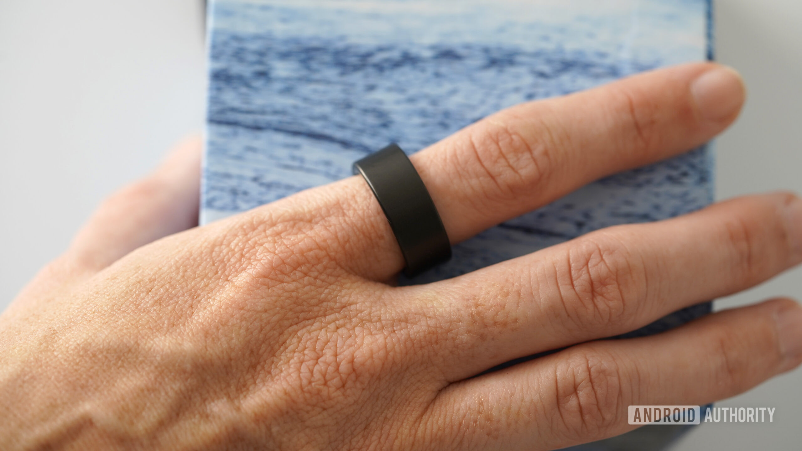 A user wears an Ultrahuman Ring Air on her index finger.