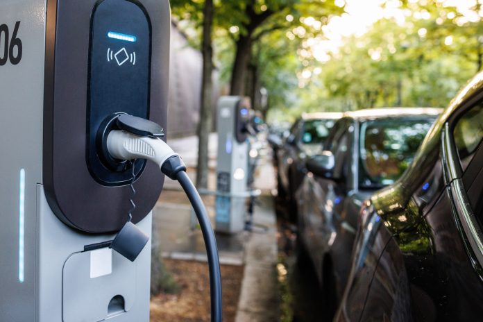 Charging EV with cable at the station in the street