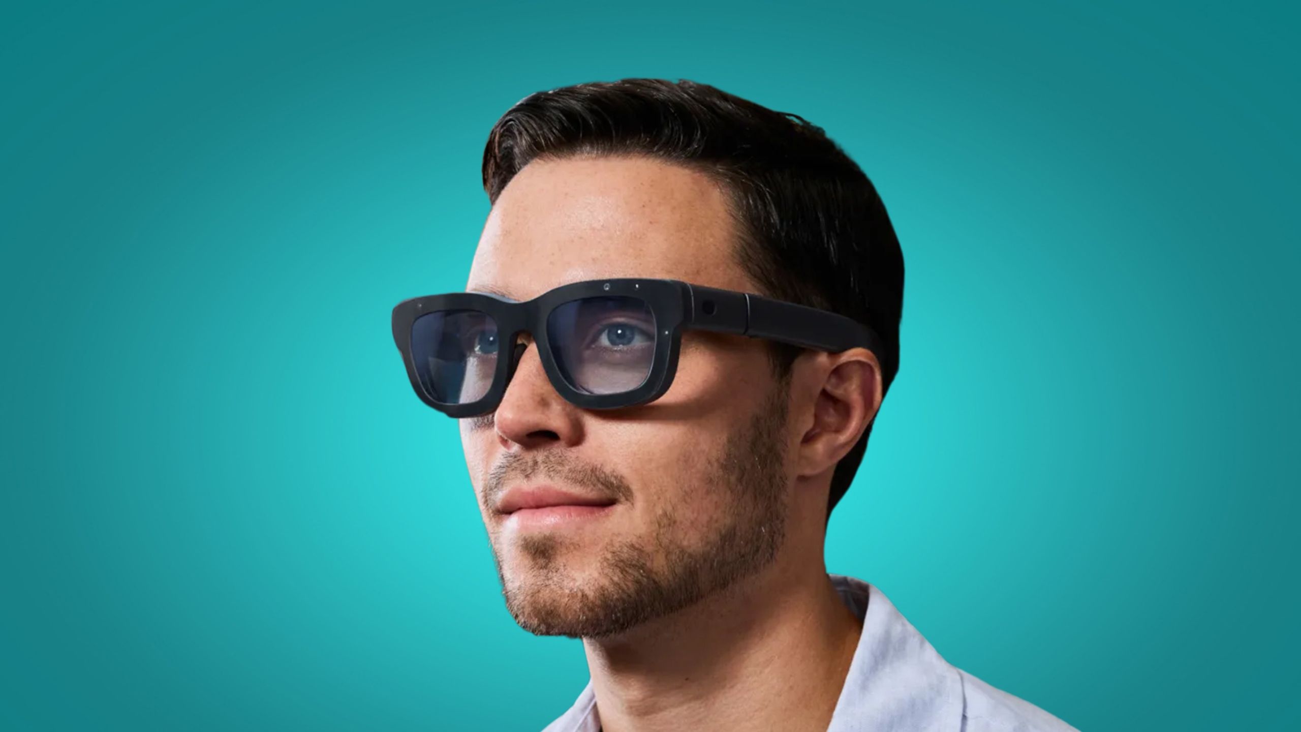 A man wearing Meta Orion AR glasses on a colored background