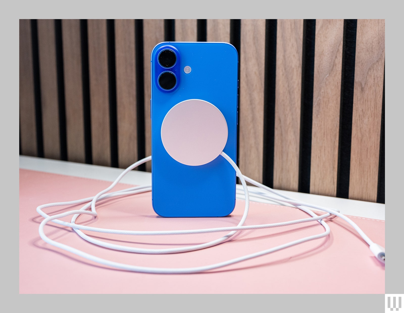 Blue mobile phone case with silver disc in the center with a cord coming from it