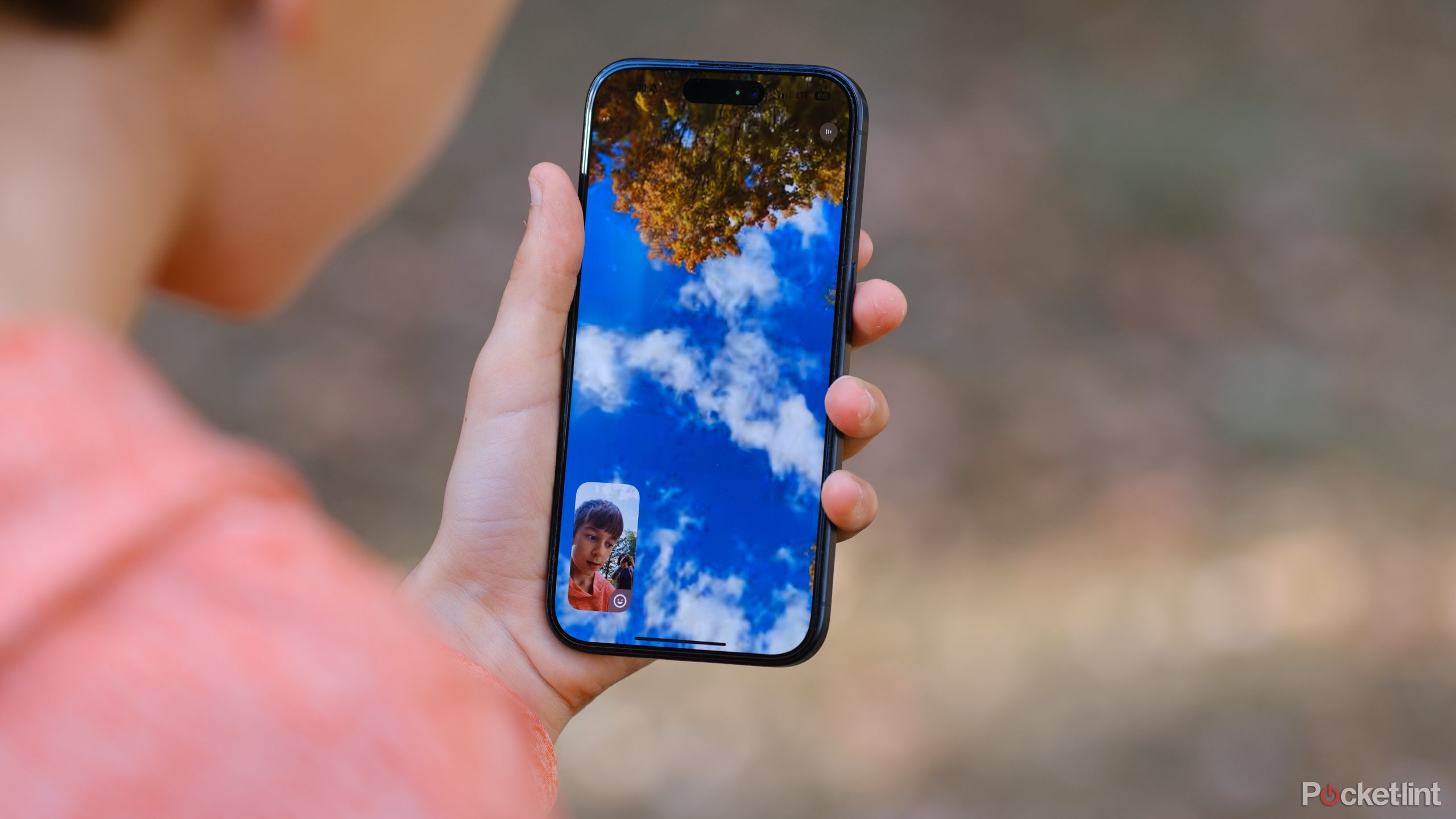 A hand holds an iPhone with a Snapchat video call