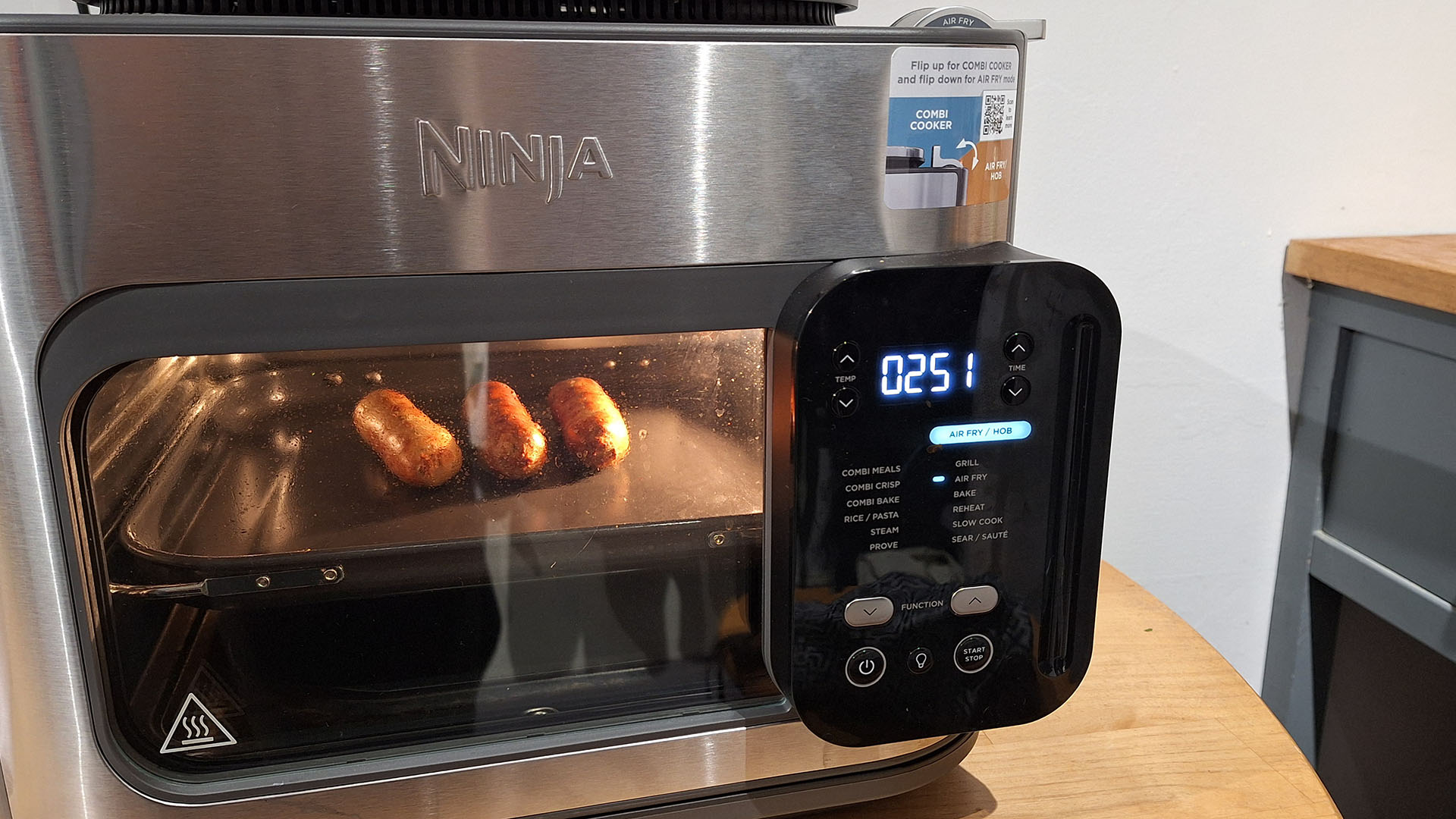 Ninja Combi Multi-Cooker with browned sausages inside