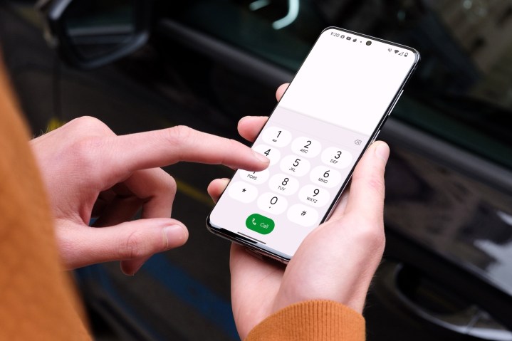 A person making a phone call on a Samsung Galaxy S24 in a car.