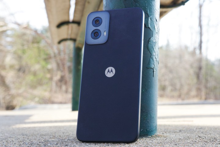 The Moto G Power 5G (2024) standing upright against a bench.