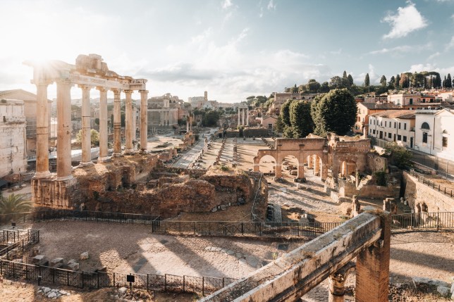 Fori Imperiali, ruins of the ancient Roman Empire and Coliseum on background. Rome, Lazio, Italy. Sunrise