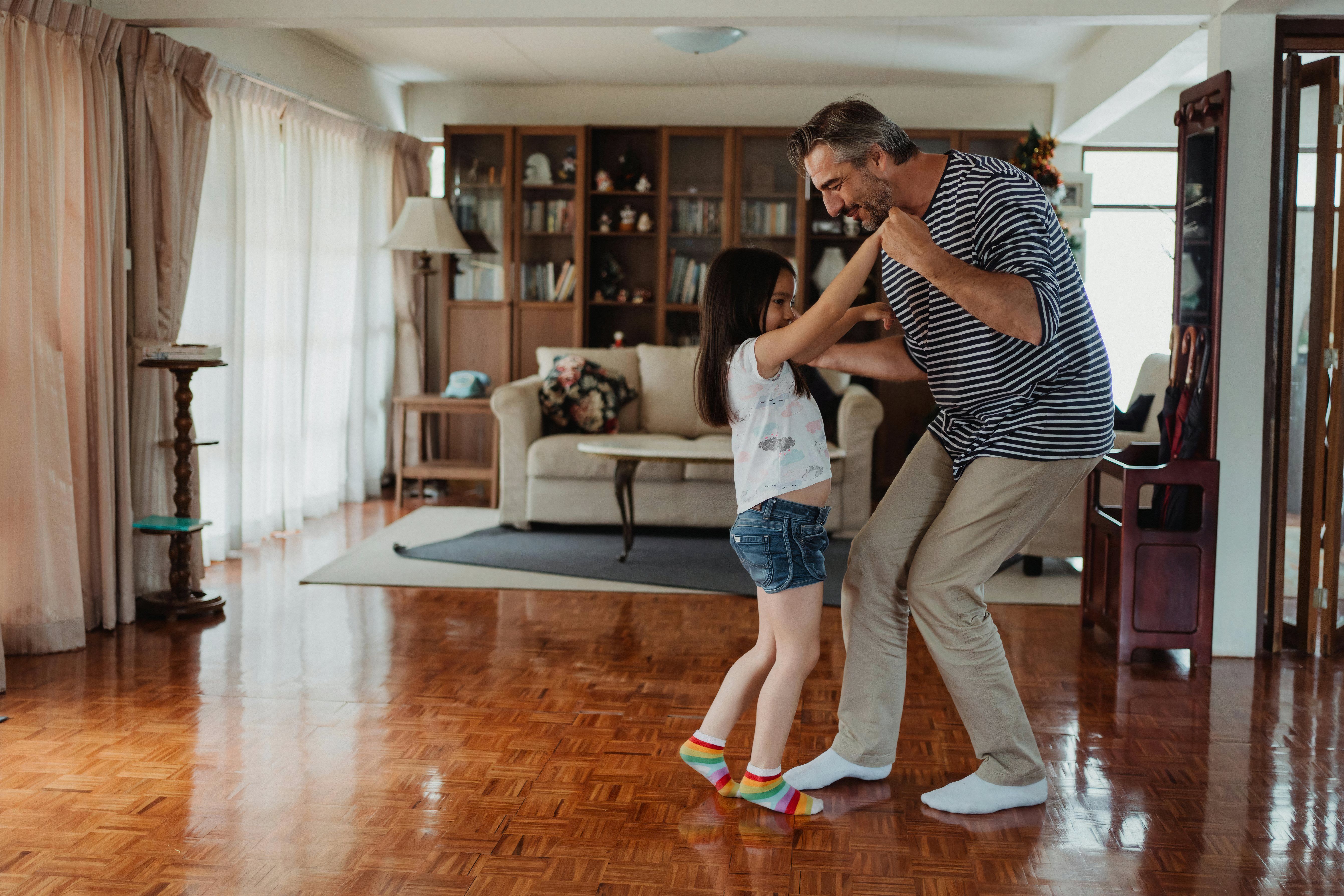 A father and his daughter dance to music