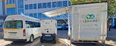 Two electric vehicles parked next to an electric charging station