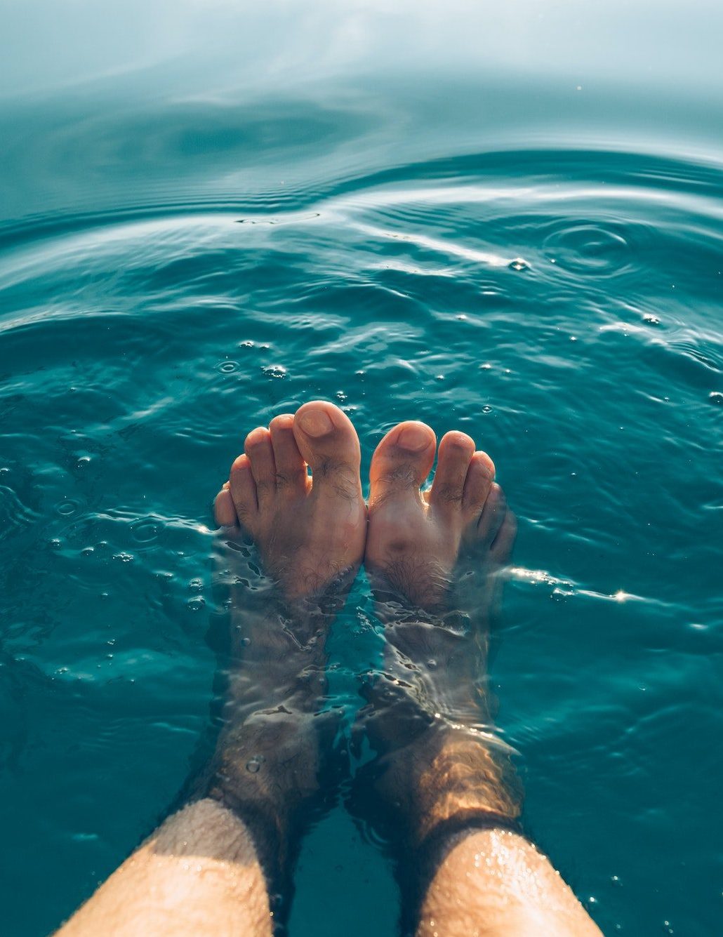 Male feet in outdoor swimming pool