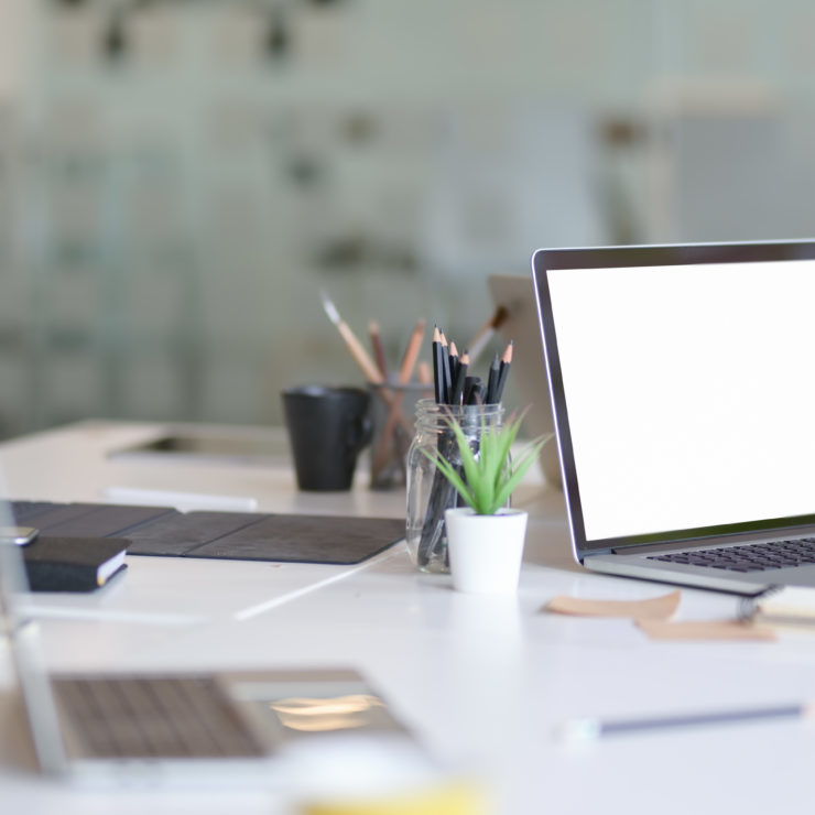 Designer's work place with open blank screen laptop