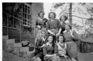 A group of Land Girls outside of a house