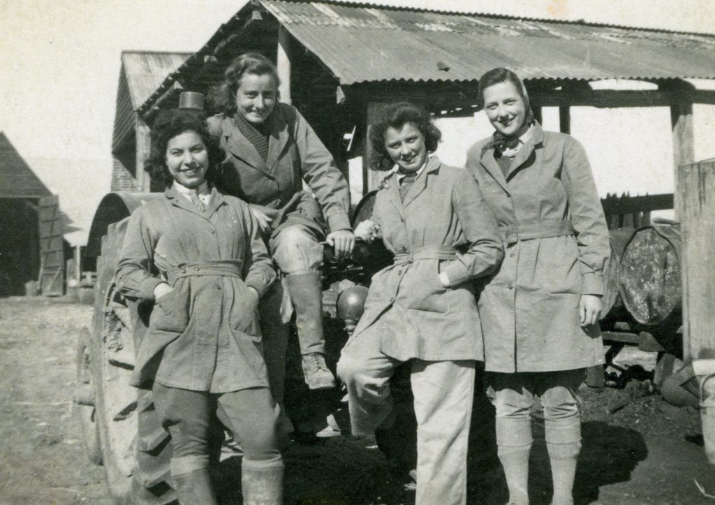 Iris, Evelyn and Friends on the farm. Evelyn is on the far right next to Iris leaning on the tractor.