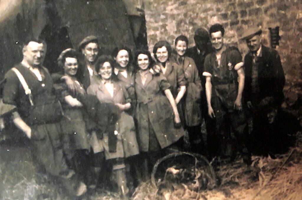 Joan Evelyn Smith pictured with fellow Land Girls and farmers.