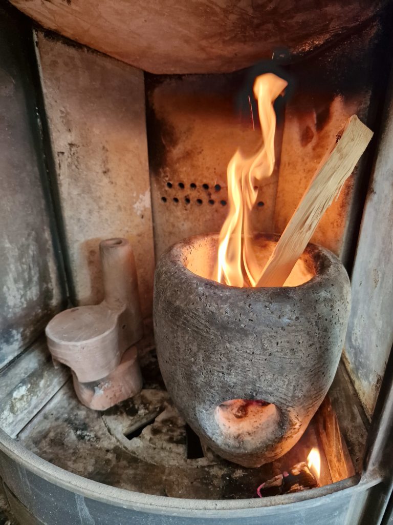 Bisque fire ceramic in an wood stove, pre heat the ceramics with a fire-pot, temperature rising