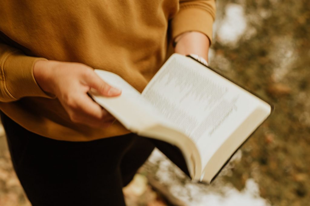 Person liest in einem aufgeschlagenen Buch