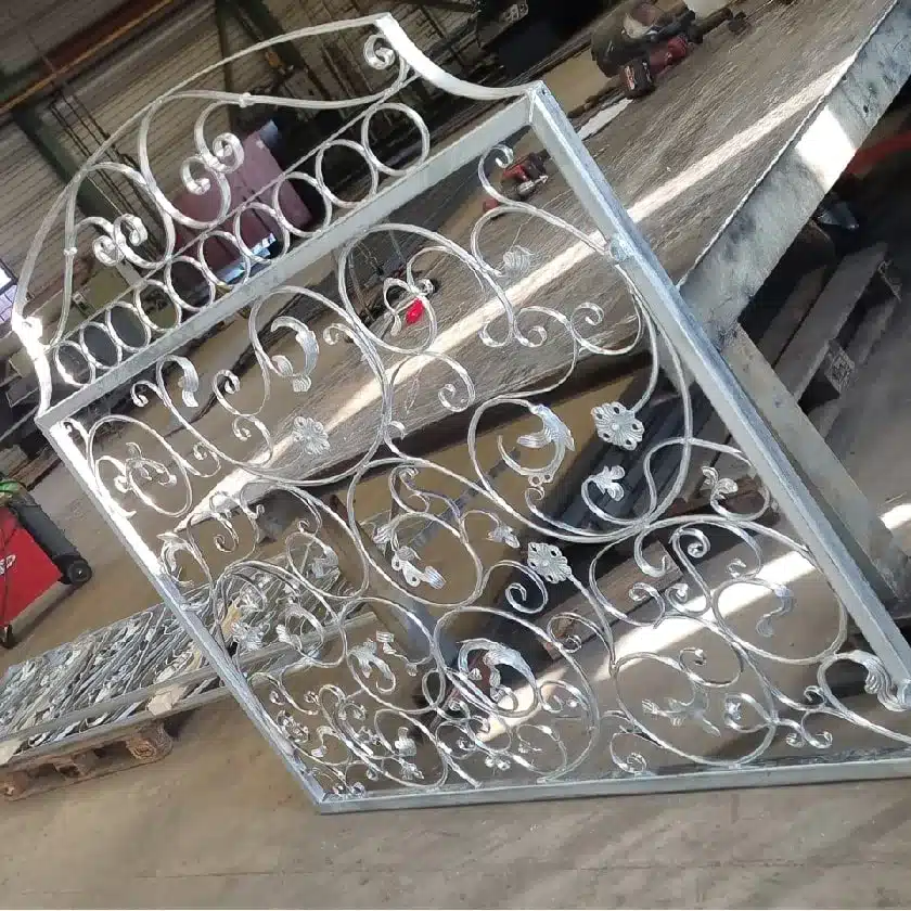 Varmförzinkad grind med böjda former och dekorationsväxter