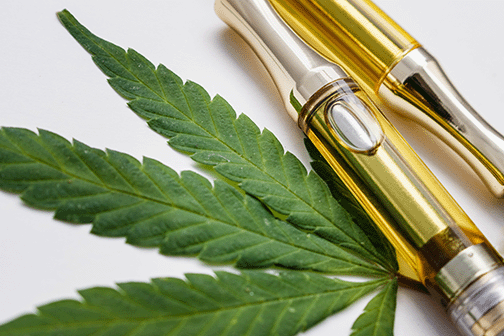 Vape Pens mit CBD Kartusche, daneben ein Cannabisblatt