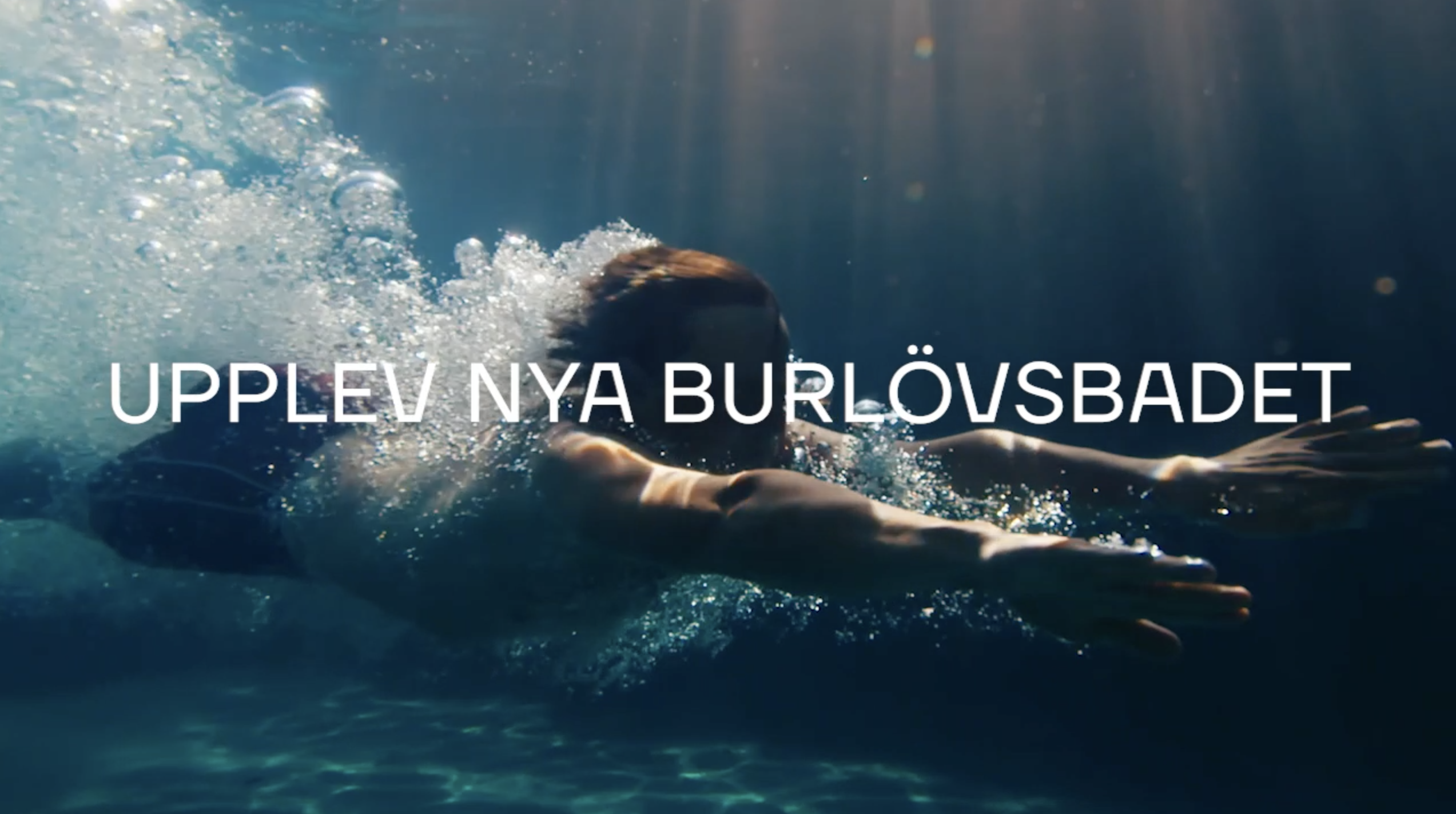 en simmare dyker under vatten. Innehåller texten "Upplev nya Burlövsbadet"