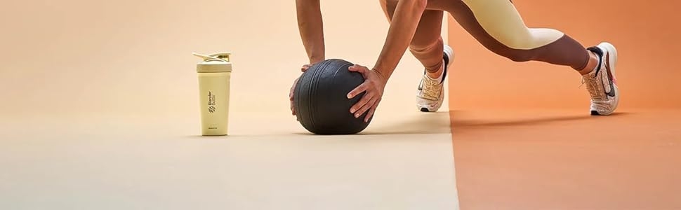 Protein shake blender yellow bottle with hands on workout ball ready to drink protein