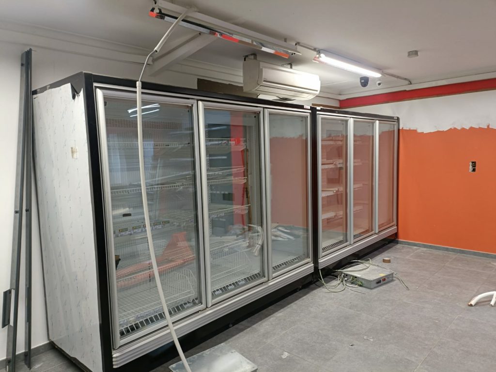 Installation de frigos vitrines professionnels en cours dans un commerce – YOU SERVICES Belgique