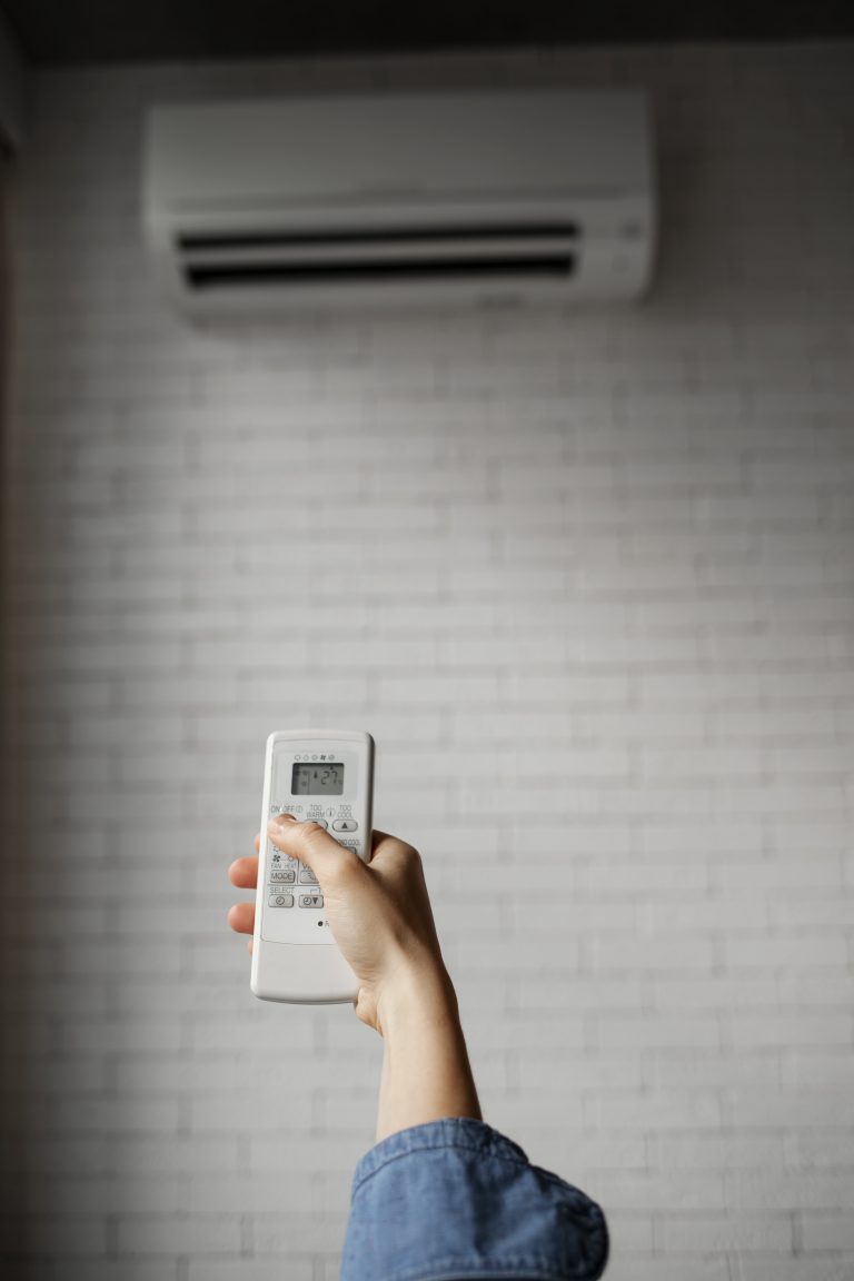 Télécommande utilisée pour allumer un système de climatisation murale dans un intérieur moderne