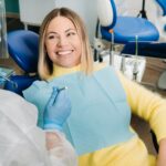 The girl smiles at the dentist and looks at her