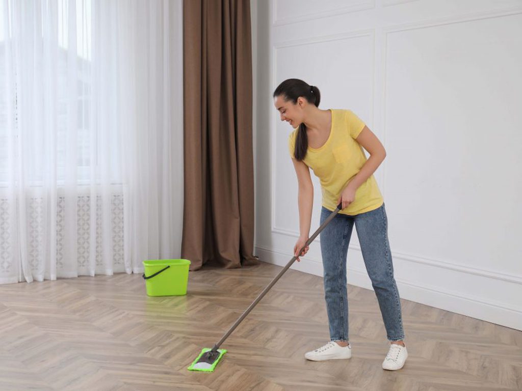 En person som städar ett golv vid en flyttstädning