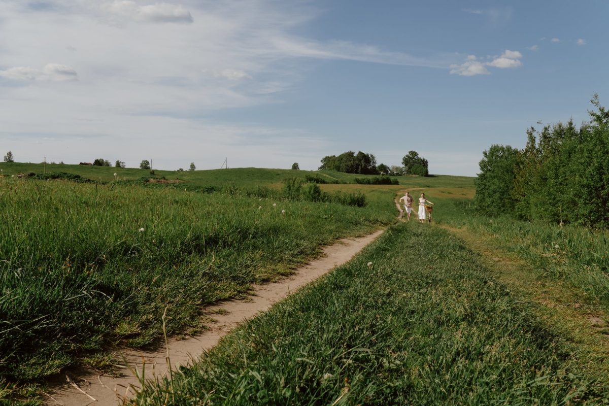 woman and man on ground road among fields