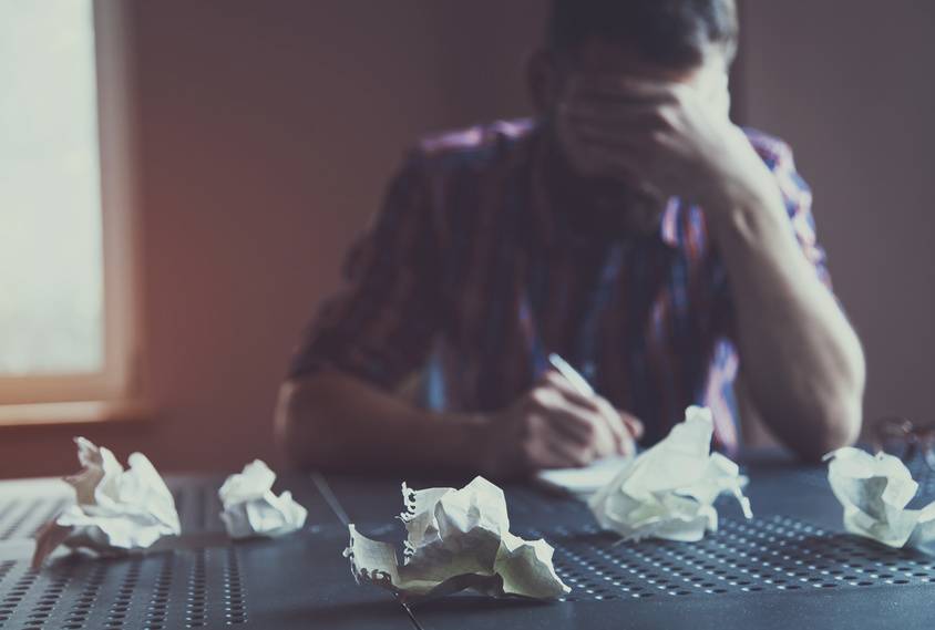 Paper balls during bearded man writing