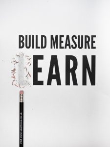 A poster saying 'build, measure, learn" with an image of a pencil eraser removing the "L" or learn