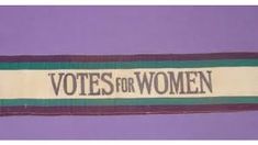 An old suffragette banner reading 'Votes for Women' in green, white and violet - the colours associated with woman's suffrage. 