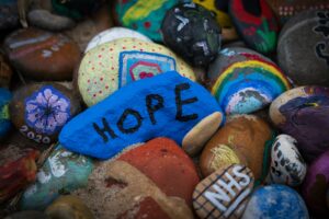 a collection of colourful painted rocks, with the central rock reading 'hope'