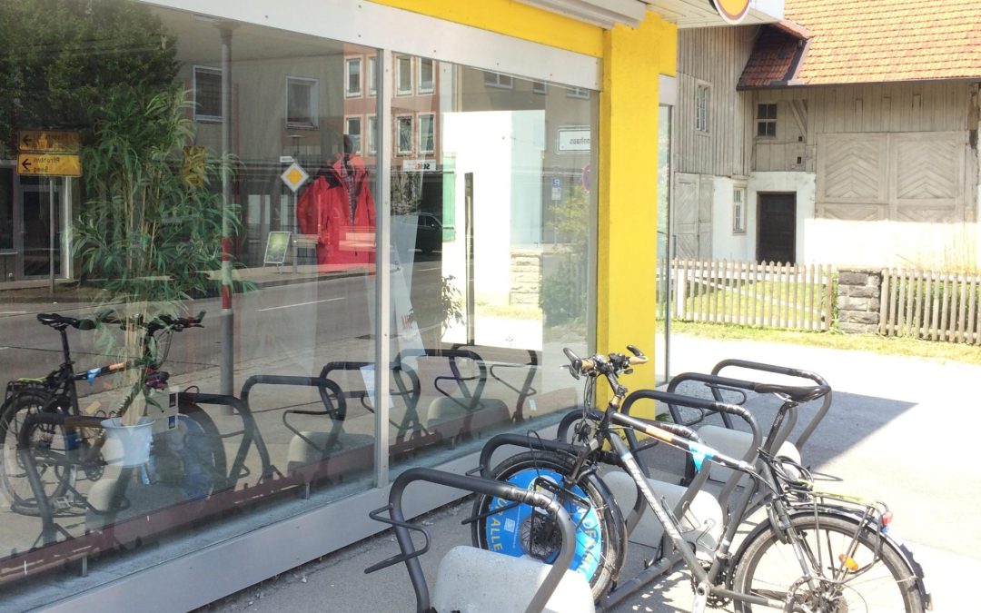 Fahrradständer mit Fahrrad vor Geschäft