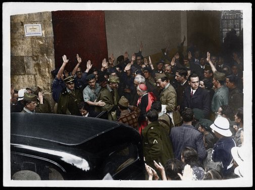 Momento en el que el escritor sale del acto acompañado de Carmen Polo de Franco -entrando en el coche- y Millán Astray. FOTO RESTAURADA Y COLOREADA POR RAFAEL NAVARRETE / ORIGINAL: MINISTERIO DEL INTERIOR / SECCIÓN TÉCNICA