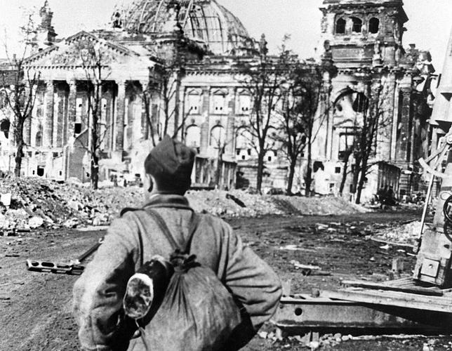 Un soldado soviético observa el edificio del Reichstag destruido