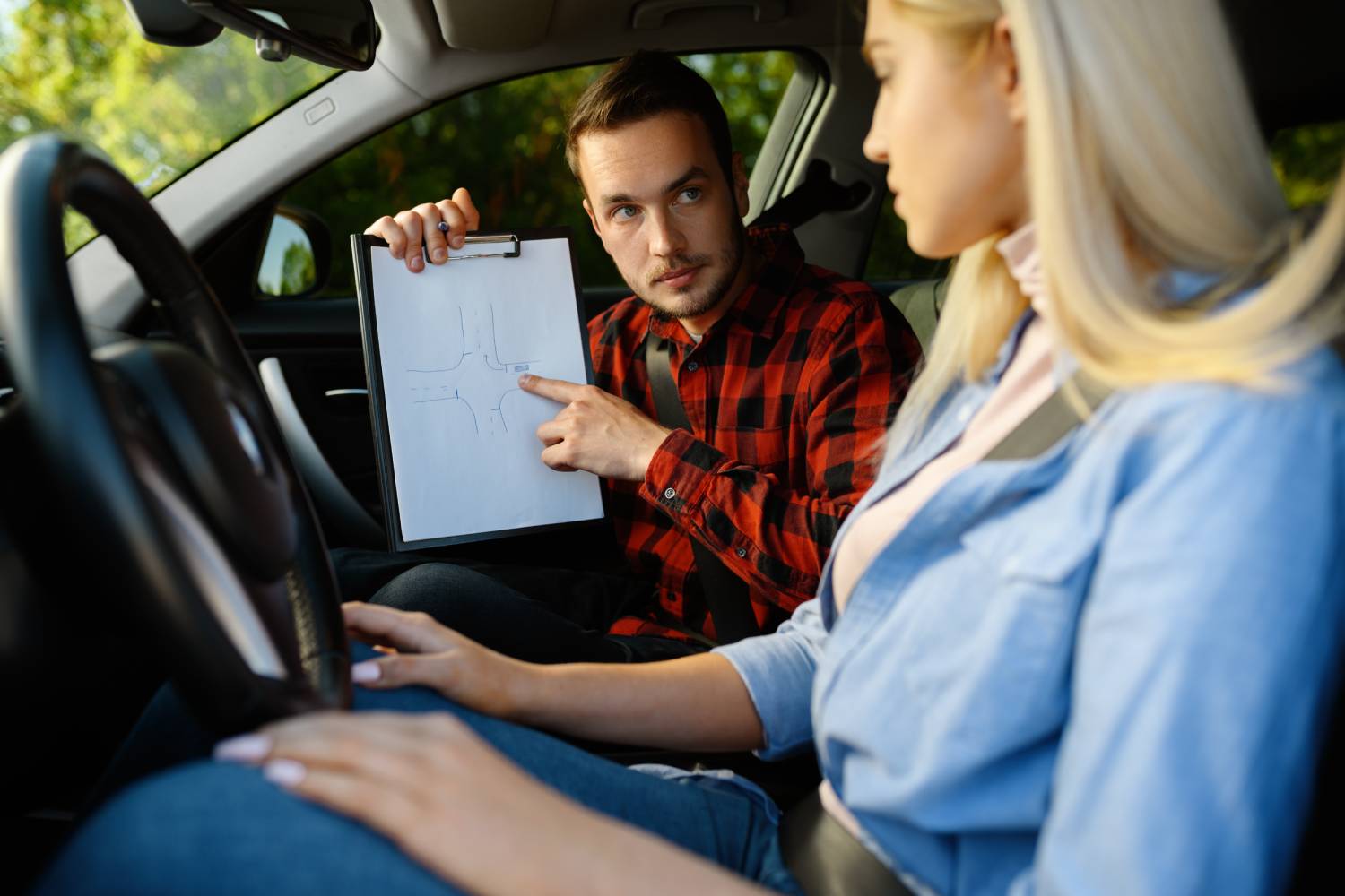 woman-instructor-with-checklist-car-driving-school-man-teaching-lady-drive-vehicle)