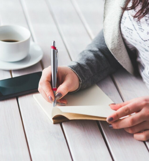 mujer escribiendo en su diario terapéutico