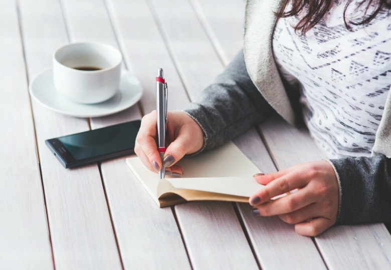 mujer escribiendo en su diario terapéutico